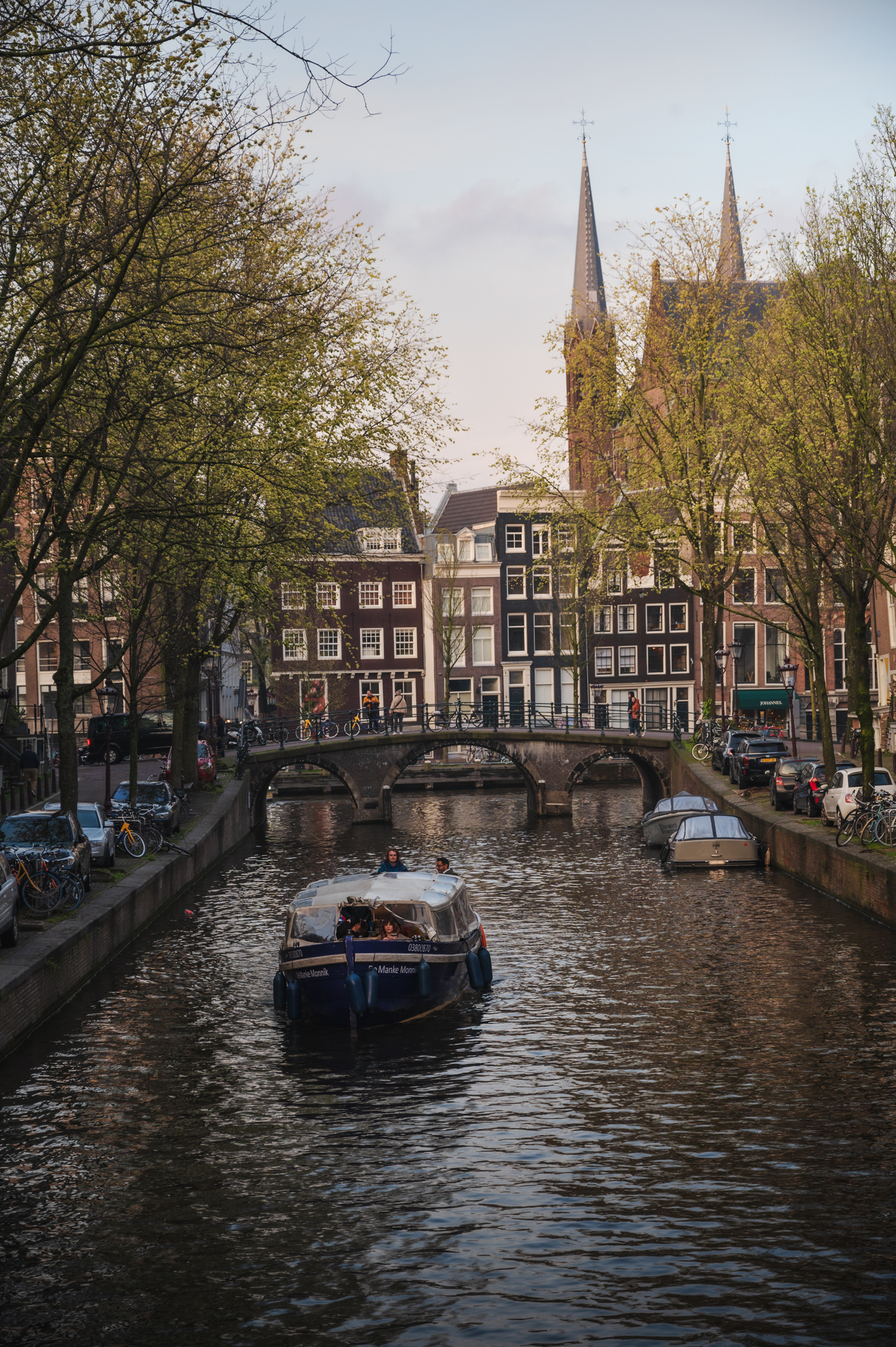 A photo of a picturesque canal in Amsterdam with a boat in the foreground.